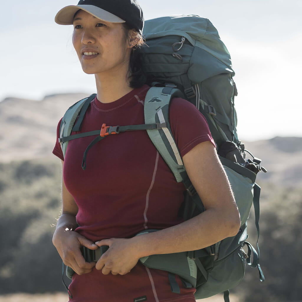 Woman Climbing with Ice axes wearing blue Macpac Jacket and Pack