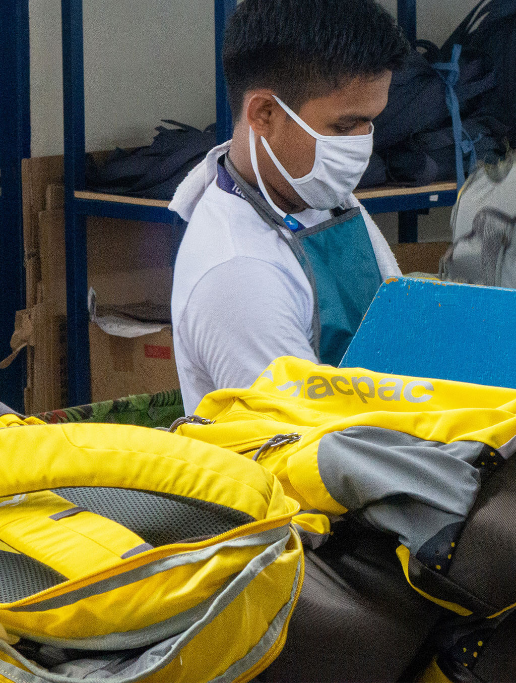 Person wearing mask making Macpac packs