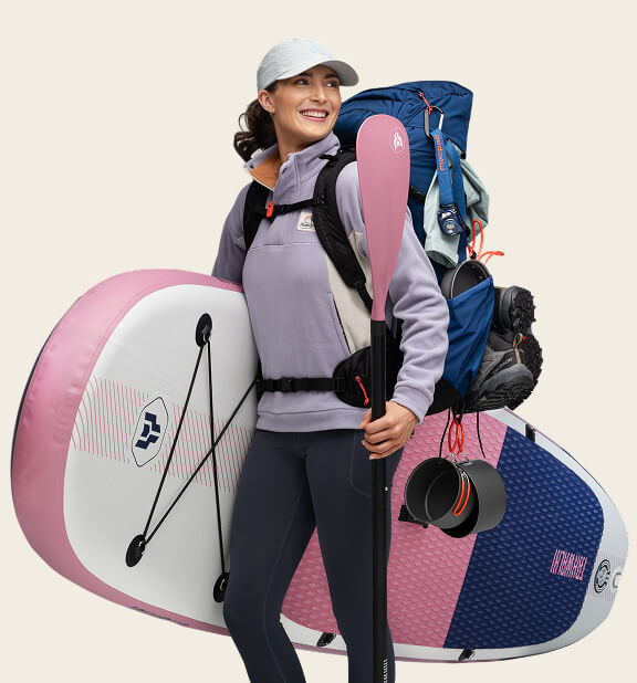 WOMAN WITH SURFBOARD AND BACKPACK