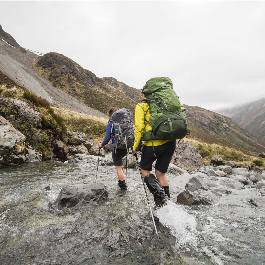 2 People walking through Highcountry Stream wearing macpac packs