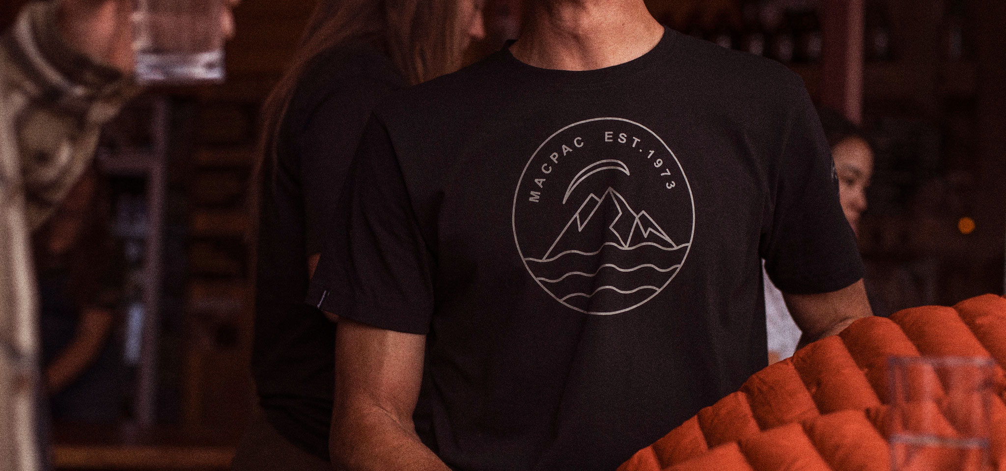 Man Wearing Black Macpac Tee Shirt that reads Macpac EST.1973